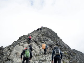 climbers hiking through mountain peak during daytime