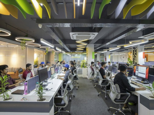 a group of people sitting at desks in an office