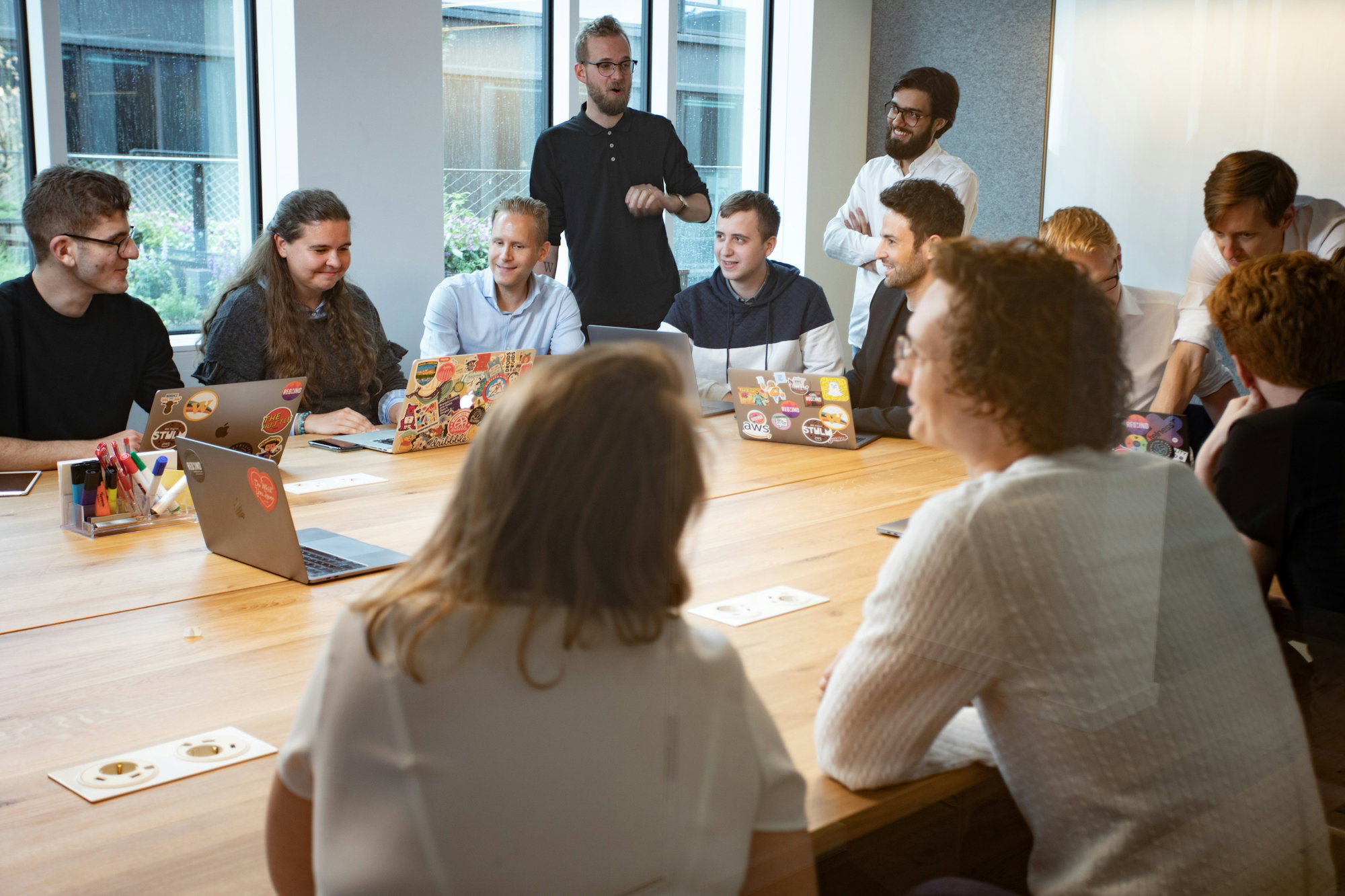 a-group-of-people-sitting-around-a-wooden-table.jpg a group of people sitting around a wooden table