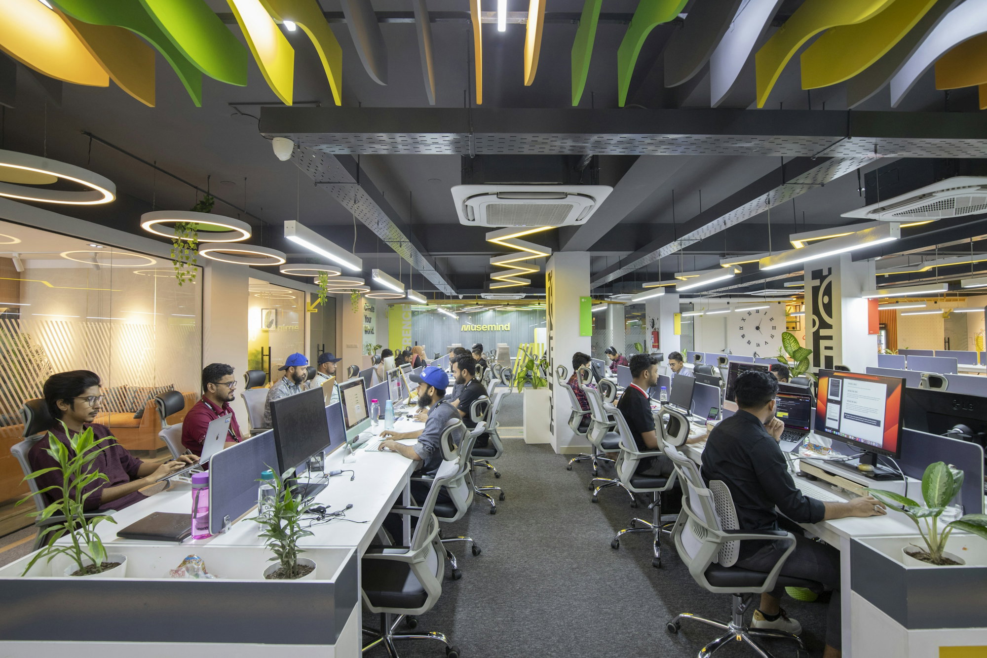 a group of people sitting at desks in an office